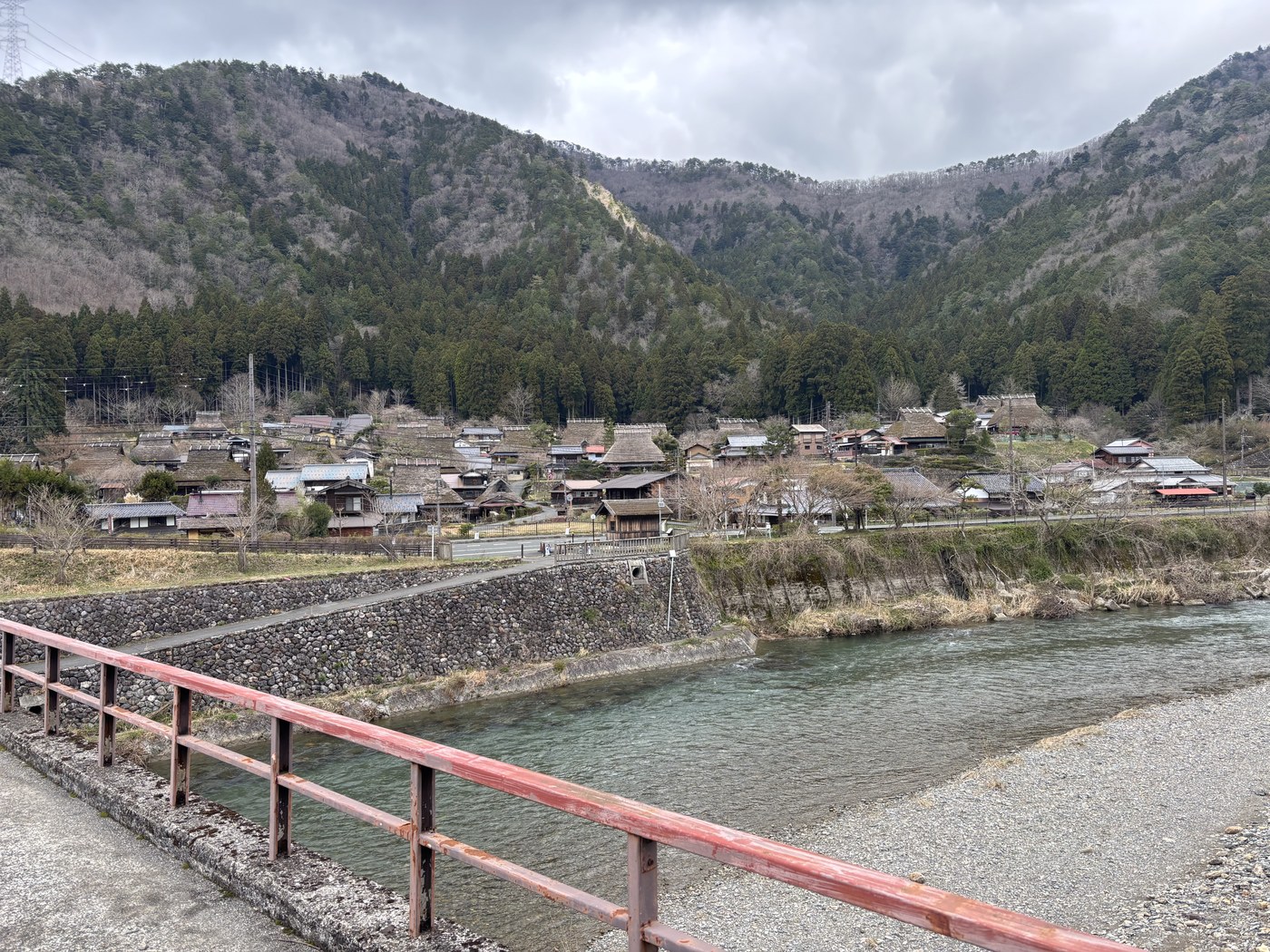 橋の上から見たかやぶきの里と川