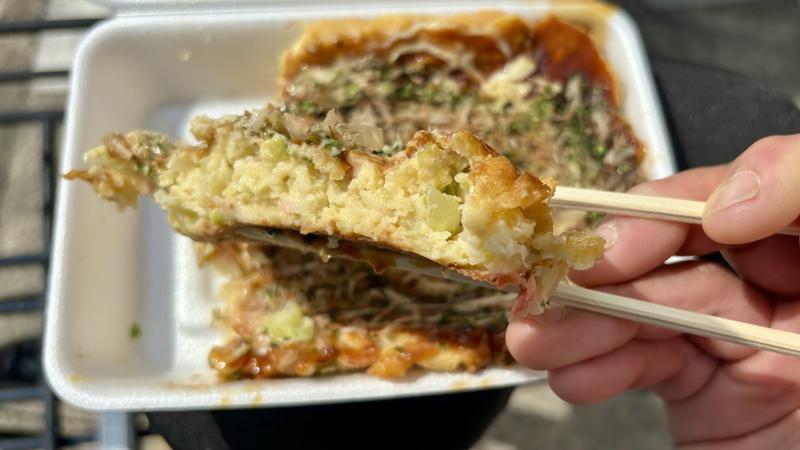割り箸で持ち上げたお好み焼きの断面