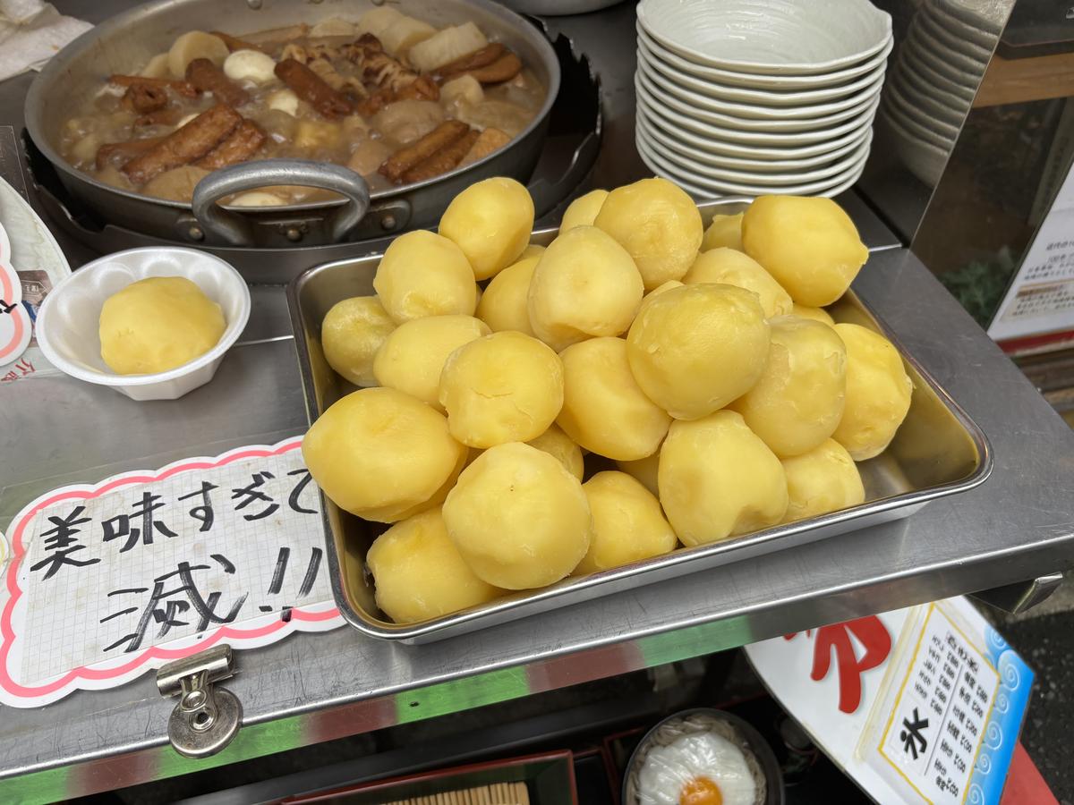 店先に並んだじゃがいもとおでんの鍋